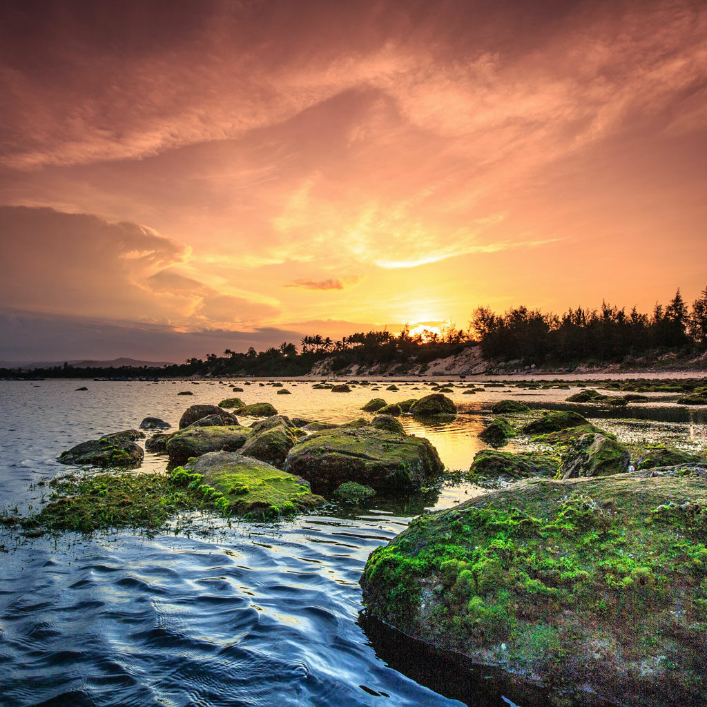 Paysage entre terre, ciel et mer sur fond de crépuscule qui évoque la beauté ainsi que la force de la nature